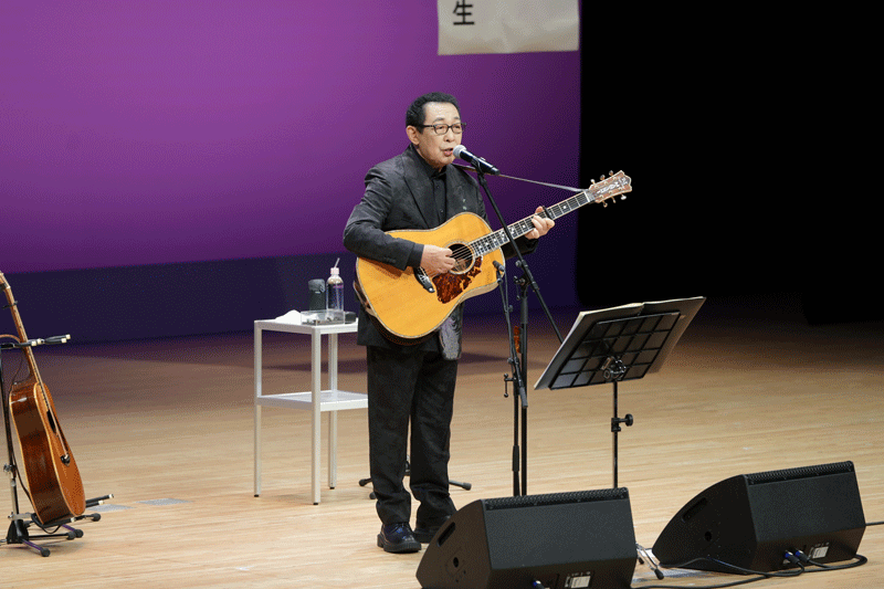 記念講演で自身の歌を披露するさだ氏